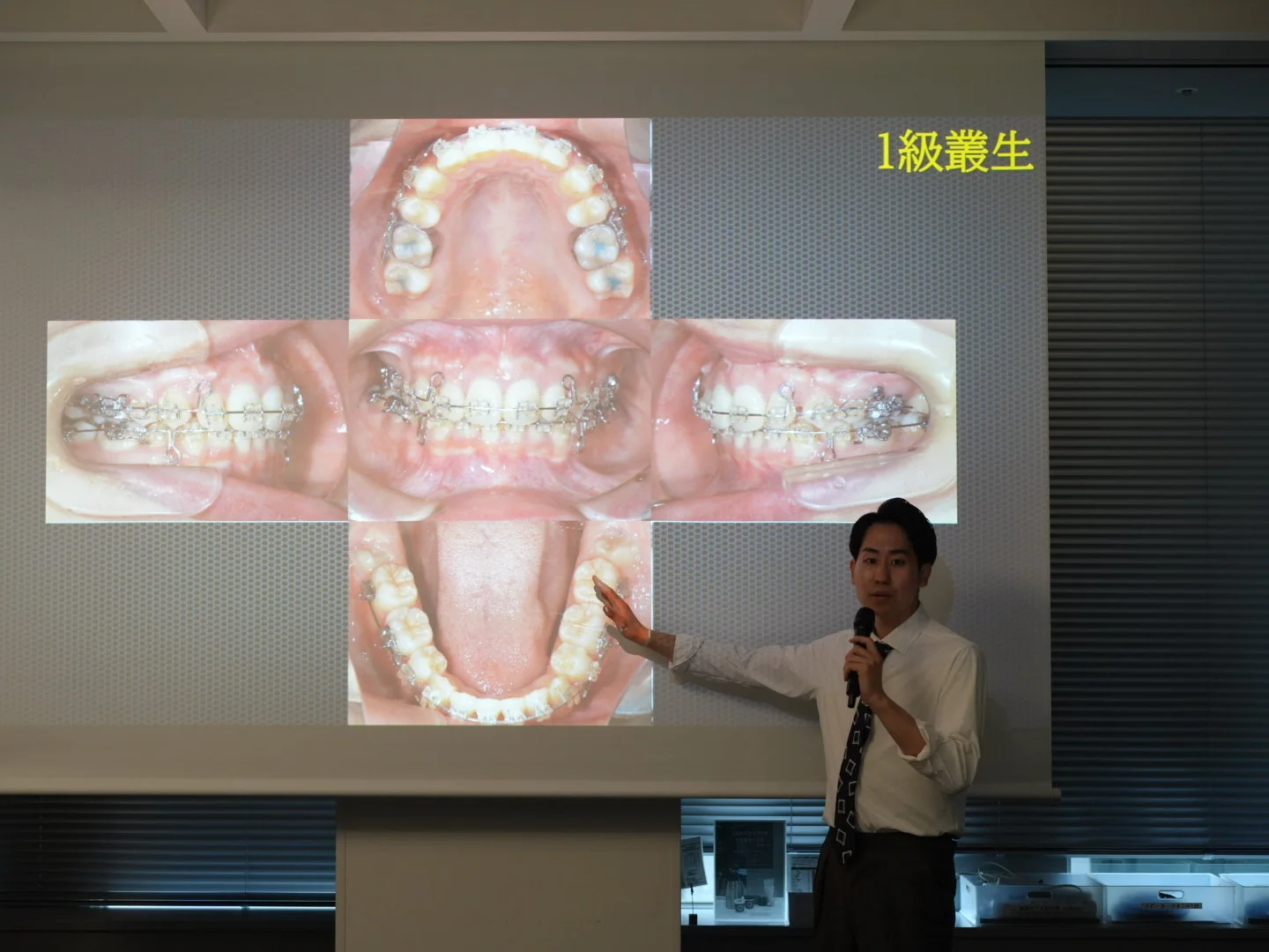 矯正GPOのセミナーで症例写真を説明する院長 岡 矢人